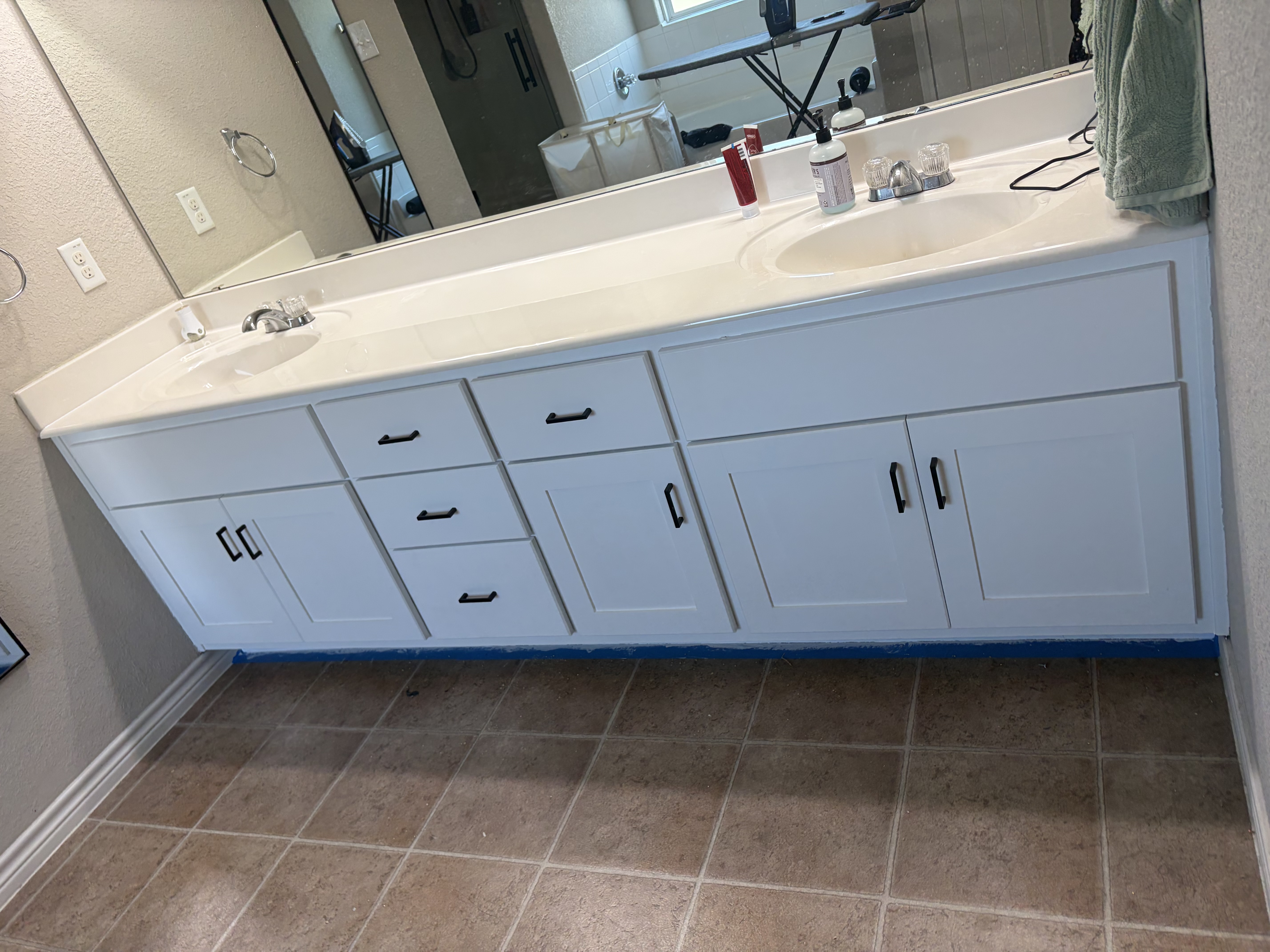 White double-sink bathroom vanity with Shaker cabinet doors and black hardware